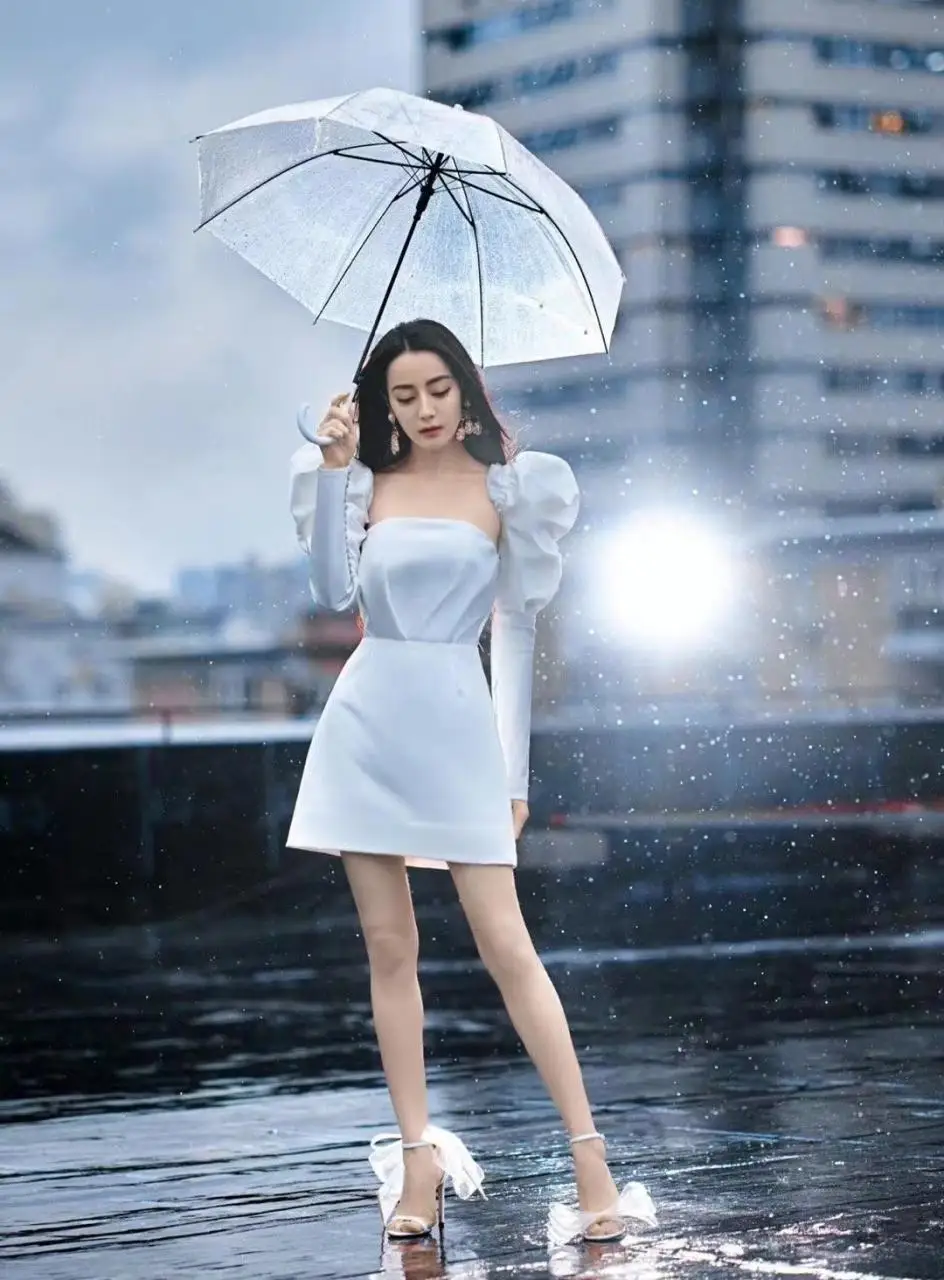 热巴久违的名场面曝光！穿白色礼服站在雨天里，打塑料伞有奢华感